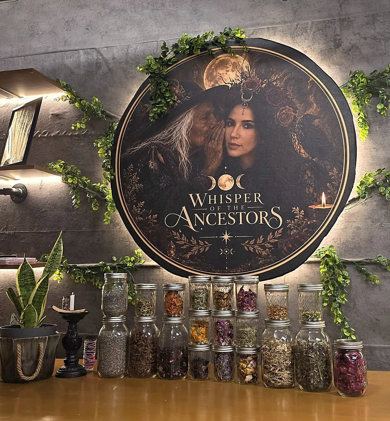 The Whisper of the Ancestors portrait above stacked botanical jars, with greenery, a potted plant and a candle beside the family workbench.
