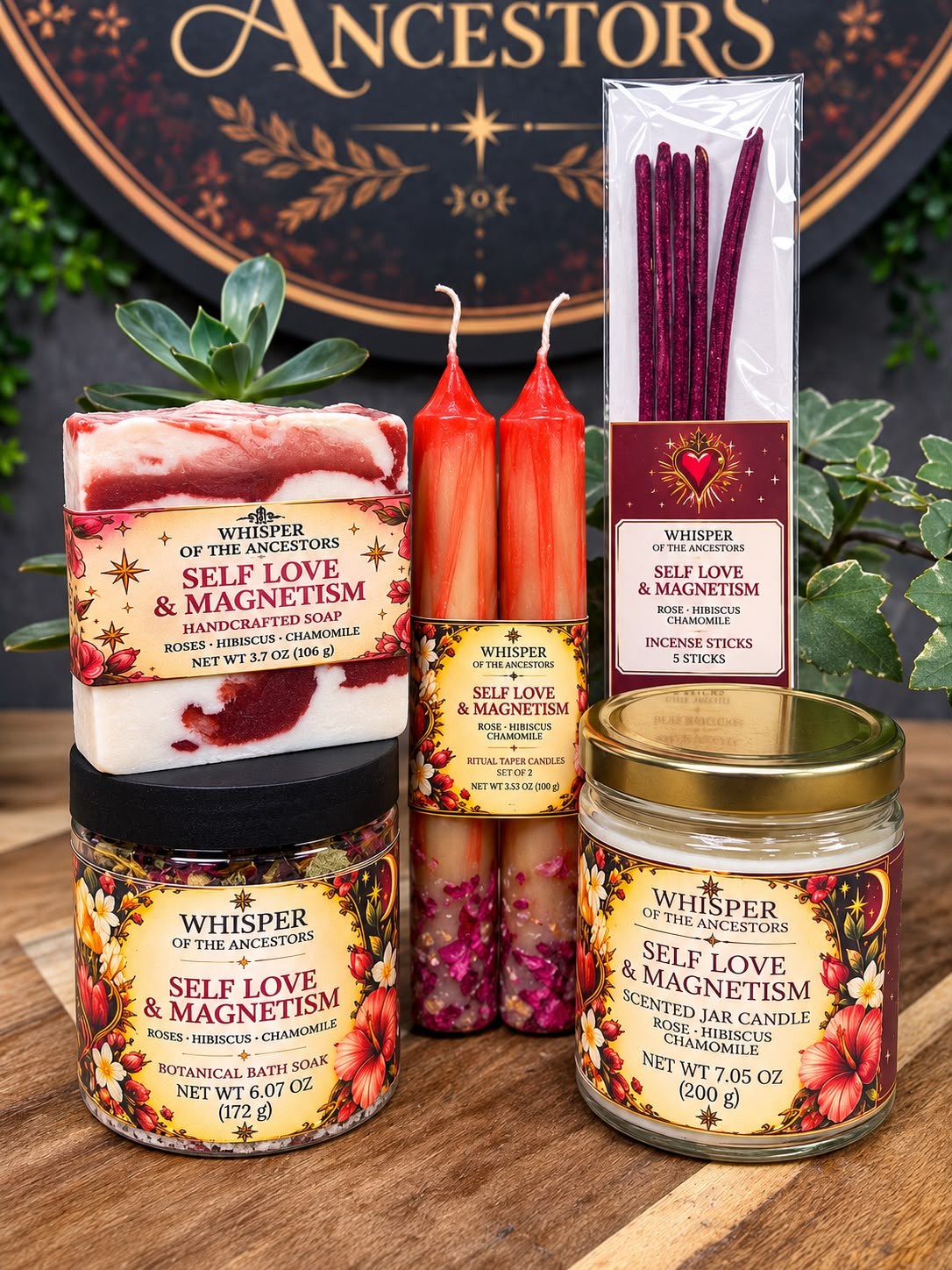 The full Self Love & Magnetism collection — marbled soap, botanical bath soak, taper candles, incense sticks and jar candle in cream, gold and deep red labels, arranged on a wooden table in front of the Whisper of the Ancestors seal